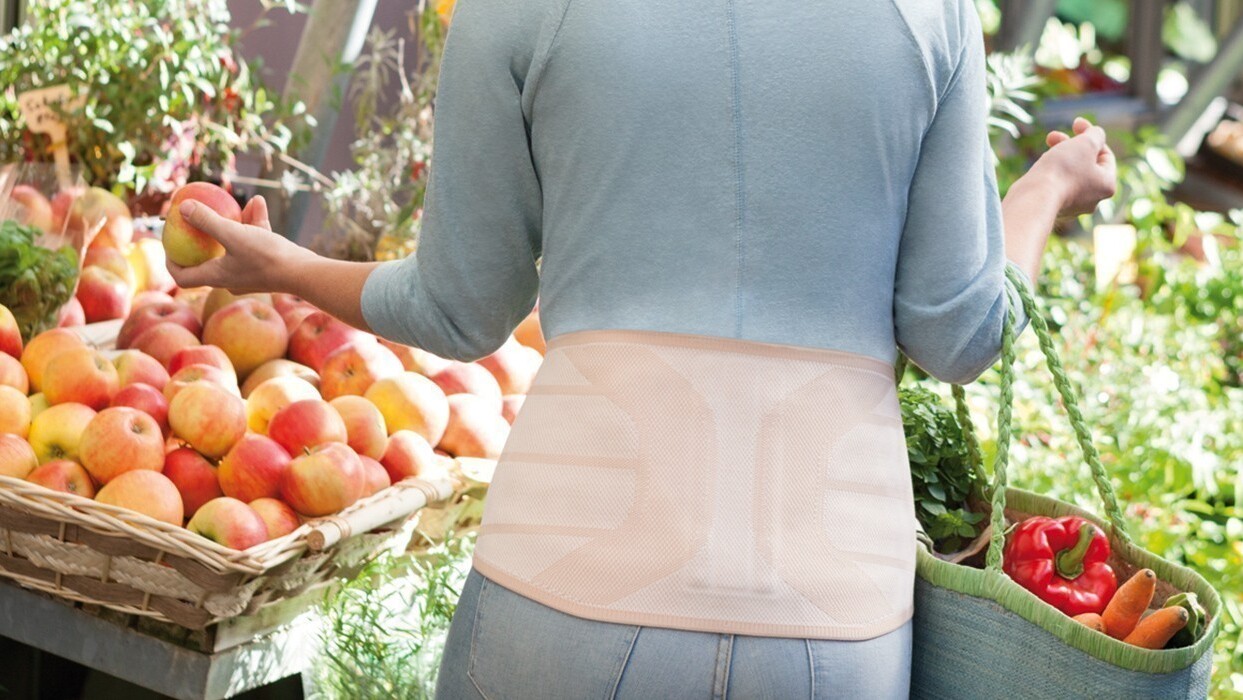 Orthèse dorsale Femme au supermarché avec orthèse dorsale