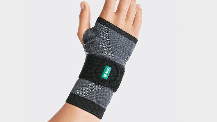 A shop assistant at the bakery wears a wrist brace at work A shop assistant at the bakery wears a wrist brace at work