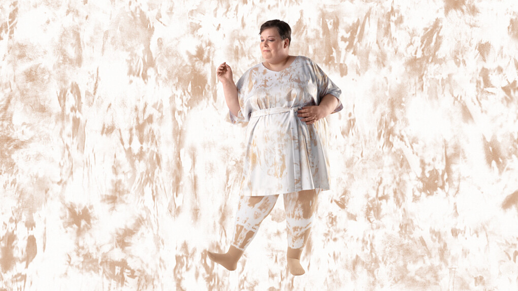 A woman wearing batik-patterned compression stockings against a batik-patterned background