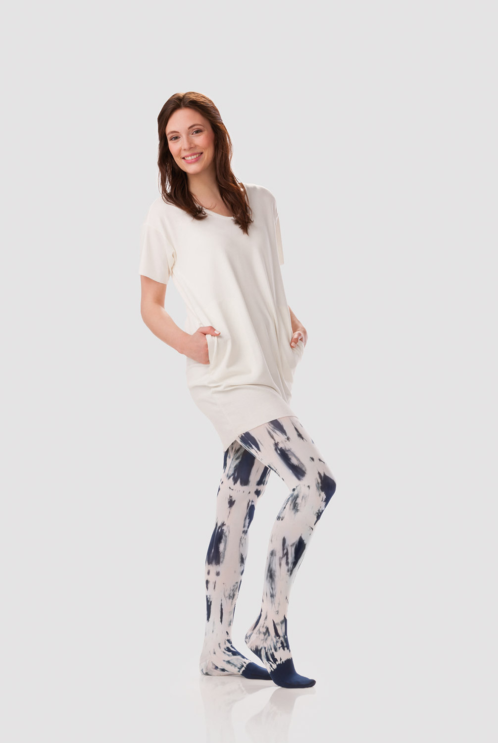A woman is wearing a white dress with a compression garment in a white and blueberry tie-dye pattern
