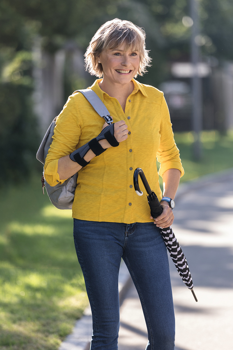 A woman is wearing a Juzo wrist brace