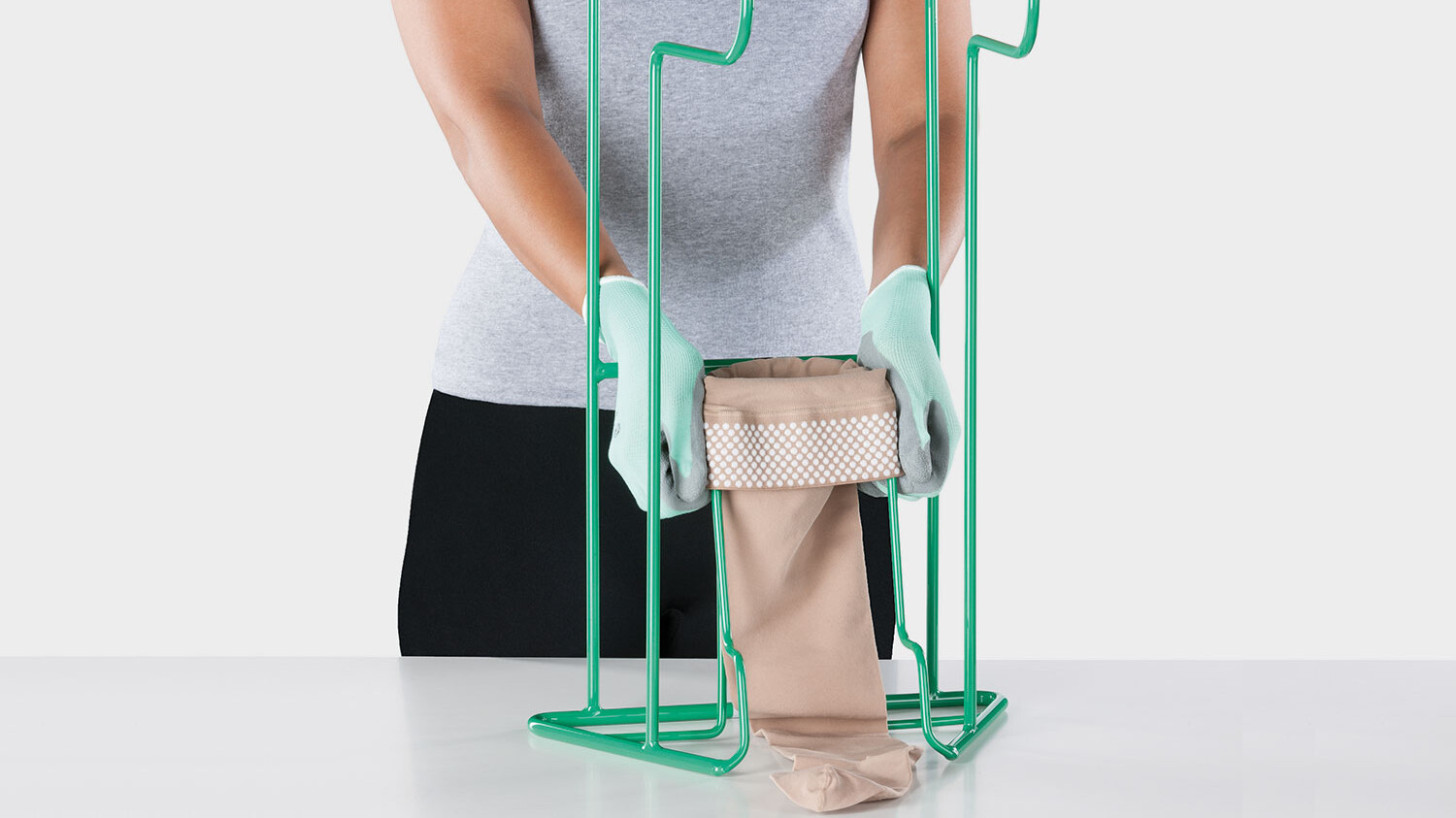 Una persona muestra el dispositivo de ayuda para vestirse Juzo Easy Fit Una persona muestra el dispositivo de ayuda para vestirse Juzo Easy Fit